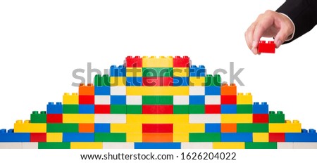 hand building up a wall by stacking up block