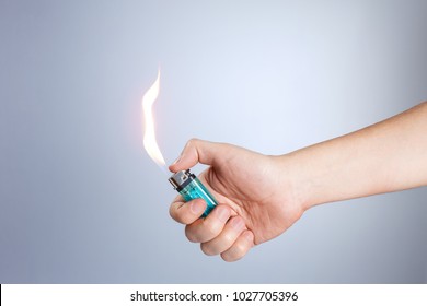 Hand burning a lighter on white background - Powered by Shutterstock