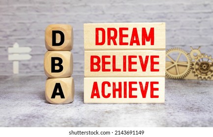 Hand of a business man completing the puzzle with the last missing piece.Concept image of Business Acronym DBA as Dream Believe Achieve