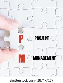 Hand Of A Business Man Completing The Puzzle With The Last Missing Piece.Concept Image Of Business Acronym PM As Project Management