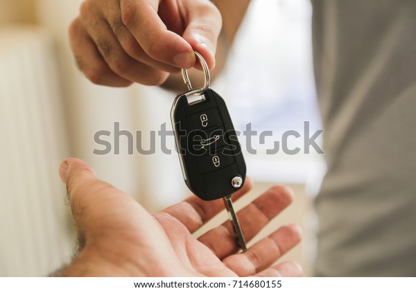 Hand of business man\
gives the car key