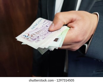 Hand Of A Business Man Holding Singaporean Banknotes 