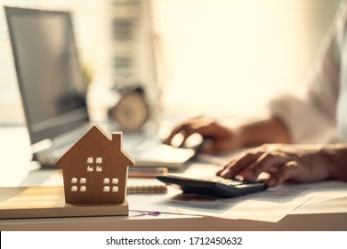 Hand of Business people calculating interest, taxes and profits to invest in real estate and home buying - Shutterstock ID 1712450632