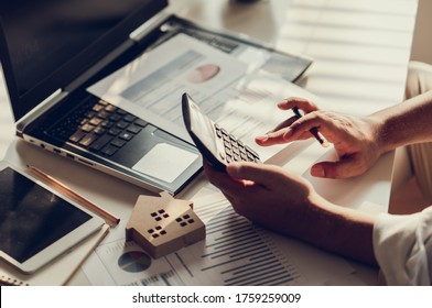 Hand of Business people calculating interest, taxes and profits to invest in real estate and home buying - Shutterstock ID 1759259009