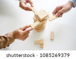 Hand of business people planning, risk and strategy in business.Businessman gambling placing wooden block on a tower.