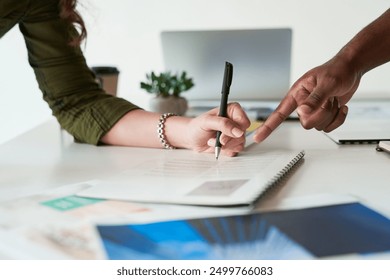 Hand, business people and team writing on document for discussion, review or feedback on portfolio. Paperwork, brainstorming or cooperation for project with graphic designer at creative startup table - Powered by Shutterstock