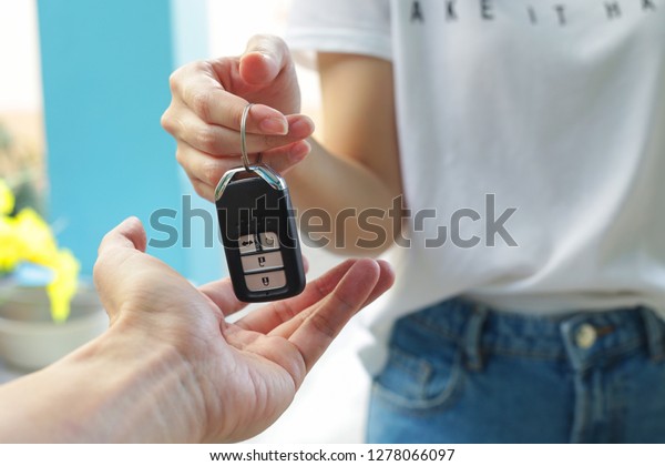 Hand of business\
woman gives the car key.