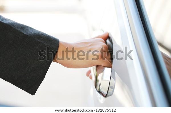 Hand business\
woman open car door. close\
up.