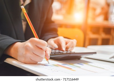 Hand business woman pointing paper data analyze chart on desk at office room. - Shutterstock ID 717116449