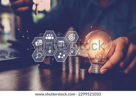 Hand businessman choose light bulb with business marketing strategy concept goal to growth of creative financial planning idea and startup strategic plan investment management or personal loan.
