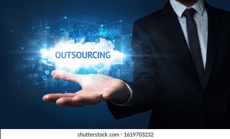 Hand of Businessman holding OUTSOURCING inscription, successful business concept