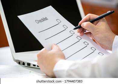 Hand Of A Businessman Holding A Pen And Checking The Checklist.