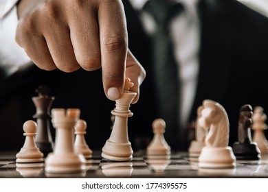 Hand des Geschäftsmanns, der Schach bewegt, in der Konkurrenz-Erfolg-Spiel. Strategie, abgeschwächter Retroeffekt.
