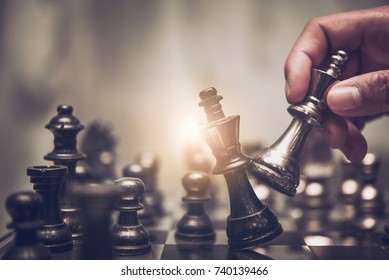 hand of businessman moving chess figure in competition success play. strategy, management or leadership concept 