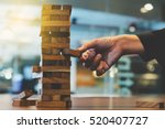 hand of businessman pulling out or placing wood block on the tower in modern office. plan and strategy in business. blur for background