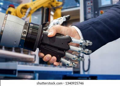 Hand Of A Businessman Shaking Hands With A  Robot. The Concept Of Human Interaction With Artificial Intelligence.