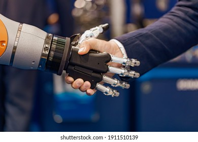 Hand eines Geschäftsmanns, der mit einem Roboter die Hand schüttelt. Das Konzept der menschlichen Interaktion mit künstlicher Intelligenz.