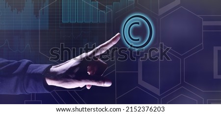 Hand of businessman touching symbol of copyright on dark blue background