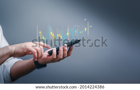Hand of Businessman or trader is showing a growing virtual hologram stock on smartphone, planning and strategy, Stock market, Business growth, progress or success concept. invest in trading.