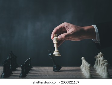 hand of businessman wearing suit moving chess figure in competition success play. strategy,teamwork, management or leadership concept.
