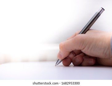 
the hand of a businessman who signs with a fine pen