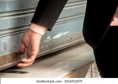 Hand Of The Businesswoman Opening The Old Rust Shutter Door.