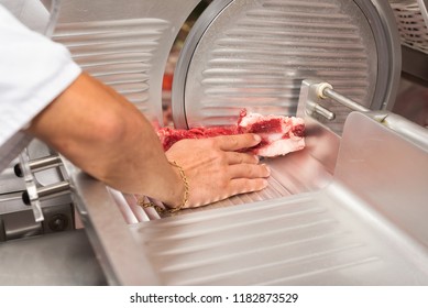 Hand Of Butcher Using Slicer Machine In Butcher Shop