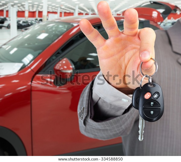 Hand with a car key. Auto dealership and
rental concept background.