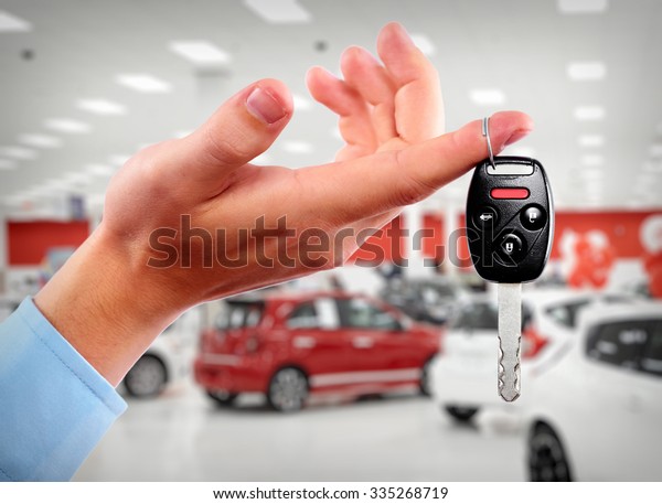 Hand with a car key. Auto dealership and
rental concept background.