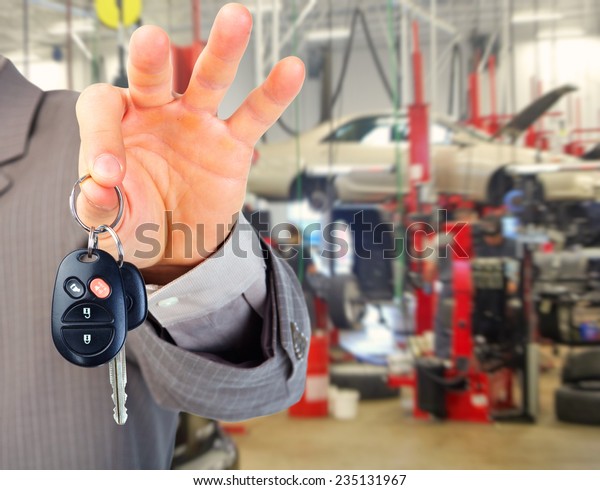 Hand with a car key.\
Auto repair service