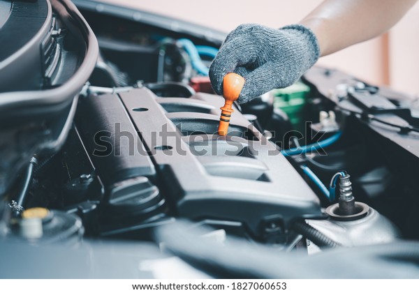 Hand of car man check engine oil of\
engine motor for maintenance and home service\
concept