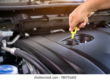Hand of car mechanic check engine oil for maintenance .
