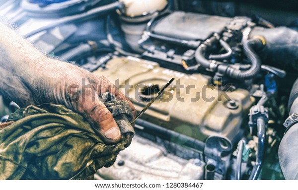 Hand of\
car mechanic check engine oil for\
maintenance
