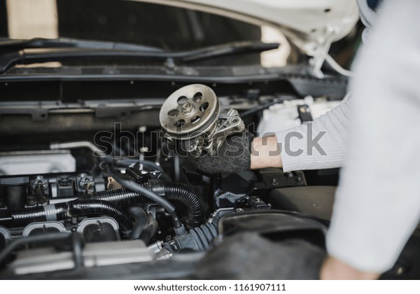 Hand of car mechanic with spare parts at service\
center repair