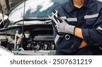 Hand of car mechanic with wrench. Auto repair garage. mechanic works on the engine of the car in the garage. Repair service. Concept of car inspection service and car repair service.