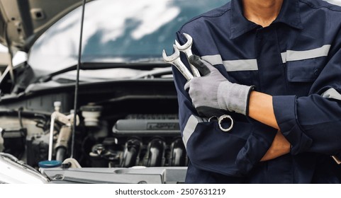 Hand of car mechanic with wrench. Auto repair garage. mechanic works on the engine of the car in the garage. Repair service. Concept of car inspection service and car repair service. - Powered by Shutterstock