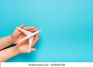 Hand carefully holding model plane. Airplane on blue color background. Security concept