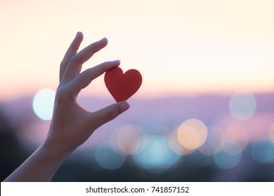hand carrying red heart - Shutterstock ID 741857152