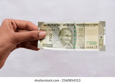 Hand catch Indian New Currency Five hundred (500 Rupees) bank note on white background.
