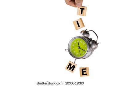 A Hand Catching A Falling Rusty Old Alarm Clock And Four Wooden Cubes Spelling 'time'. Levitation Photography, 'time' Concept.