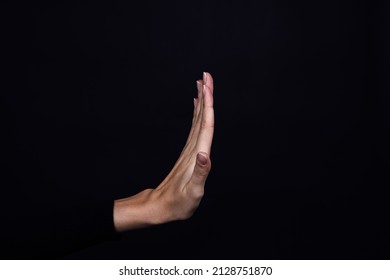 Hand of Caucasian person showing stop sign on black background. Domestic physical and psychological abuse, relative aggression, gaslighting and social injustices. Copy space.