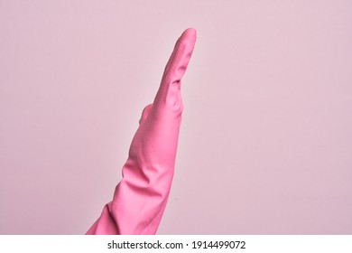 Hand of caucasian young man with cleaning glove over isolated pink background showing side of stretched hand, pushing and doing stop gesture - Shutterstock ID 1914499072