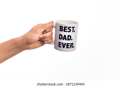 Hand Of Caucasian Young Man Holding Cup Of Coffee With Best Dad Ever Message Over Isolated White Background