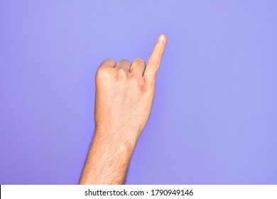 Hand of caucasian young man showing fingers over isolated purple background showing little finger as pinky promise commitment, number one