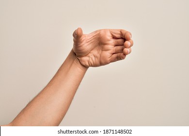 Hand of caucasian young man showing fingers over isolated white background holding invisible object, empty hand doing clipping and grabbing gesture - Powered by Shutterstock