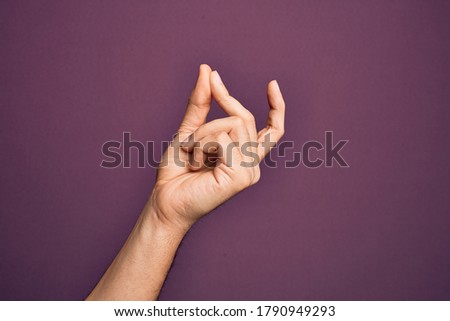 Hand of caucasian young man showing fingers over isolated purple background snapping fingers for success, easy and click symbol gesture with hand