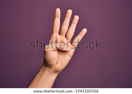 Hand of caucasian young man showing fingers over isolated purple background counting number 4 showing four fingers