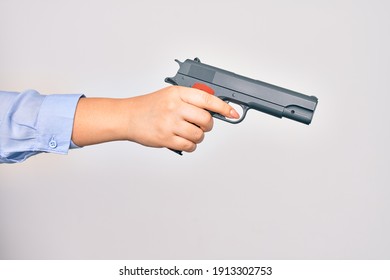 Hand Of Caucasian Young Woman Holding Gun Over Isolated White Background