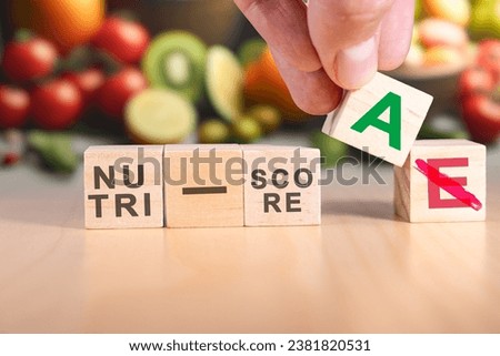 Hand changing the expression nutri-score E to nutri-score A.