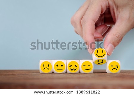 Hand Changing with smile emoticon icons  face on Wooden Cube,hand flipping unhappy turning to happy symbol